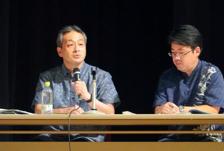 沖縄県宮古島市で開催された「防衛セミナー」で説明する防衛省の川上直人防衛政策課長（左）＝１９日午後