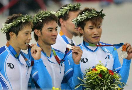2004年アテネ五輪の自転車男子チームスプリントで銀メダルを獲得した日本チーム。左から伏見俊昭、井上昌己、長塚智広の3選手(共同)