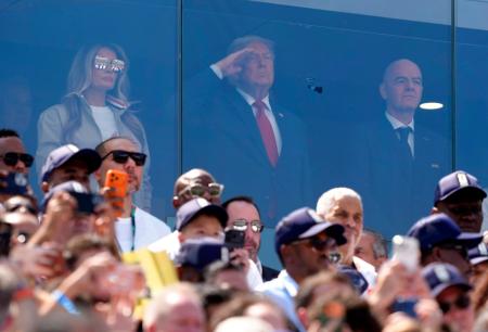 決勝のスペイン―アルゼンチン戦の観戦に訪れ、国歌斉唱時に敬礼するトランプ米大統領（中央）。右はＦＩＦＡのインファンティノ会長＝ニューヨーク（共同）