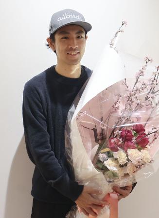 現役最後のレースを終えて帰国し、花束を手に写真に納まるノルディックスキー複合男子の渡部暁斗=3月、羽田空港