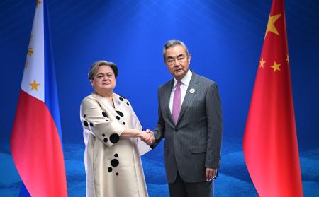 中国の王毅外相（右）と握手するフィリピンのラザロ外相＝２２日、マニラ（ＡＰ＝共同）
