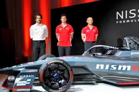 日産自動車のフォーミュラＥのマシンとトマソ・ボルペ監督（左）らチームメンバー＝２２日、東京都港区