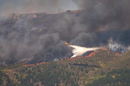 航空機による山火事の消火作業=24日、スペイン・アビラ県(AP=共同)