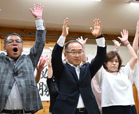 　佐賀県玄海町長選で初当選を決め、万歳する日高大助氏（中央）＝２６日夜、玄海町