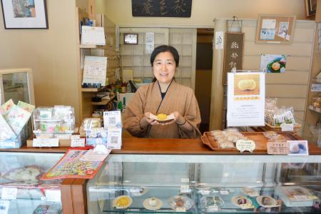 大坂家の店頭に立つ倉本朋実さん＝東京都港区