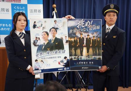 採用案内のポスターを掲げる出入国在留管理庁の職員＝２８日午前、法務省