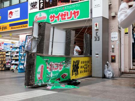　地震の影響で落下した店舗の看板＝２８日午後５時２１分、熊本市