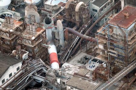 地震の影響で折れた日本製紙の八代工場の煙突＝２８日午後７時５分、熊本県八代市（共同通信社ヘリから）