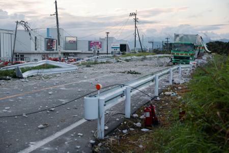 爆発から一夜明けたイオンモール熊本(奥)周辺。破片などが散乱していた=29日午前5時50分、熊本県嘉島町