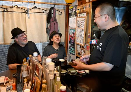 「北の屋台」の店内で笑顔で話す客と店主=29日午後、北海道帯広市