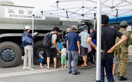 熊本県氷川町役場で給水車に並ぶ人たち＝３０日午前９時３７分