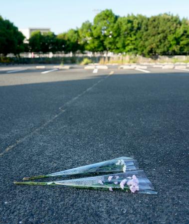 「イオンモール熊本」前の駐車場に供えられた花束=31日午前6時42分、熊本県嘉島町