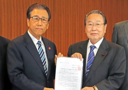 自民党札幌市支部連合会会長の三上洋右市議（右）から要望書を受け取る札幌市の秋元克広市長＝３１日午前、札幌市