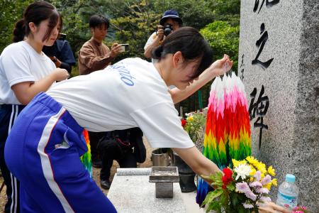 御巣鷹の尾根に立つ「昇魂之碑」に千羽鶴を供える生徒＝３１日午前、群馬県上野村