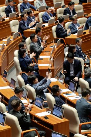 ３１日、韓国国会で、刑事訴訟法改正案の可決を喜ぶ与党「共に民主党」の議員ら（聯合＝共同）