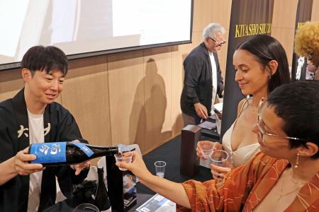 日本酒試飲会の参加者に酒を注ぐ木屋正酒造の関係者（左）＝７月３１日、米ロサンゼルス（共同）