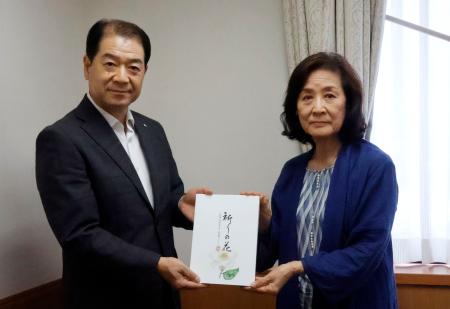 群馬県上野村役場で写真に納まる、本を寄贈した片桐悦子さん（右）と黒沢八郎村長＝１日午後