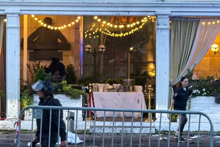 1日、爆発があったモスクワ中心部の飲食店で活動する捜査員ら(タス=共同)