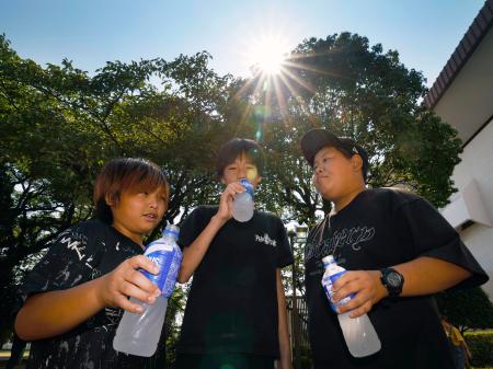 厳しい暑さとなり、水分補給する子どもたち＝３日午前、熊本県八代市