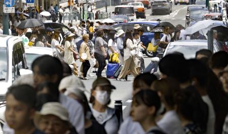 気温４０度に迫る猛暑日となった京都市内を歩く人たち＝７月２３日