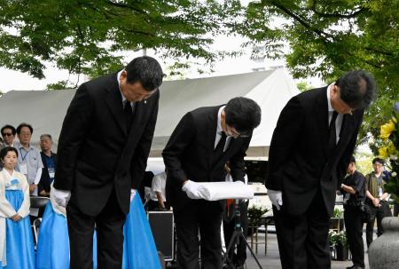 韓国人被爆者の名簿を奉納する民団広島県地方本部の金基成団長（左）ら＝５日午前、広島市