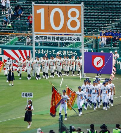 第１０８回全国高校野球選手権大会の開会式で入場行進する沖縄尚学（手前）の選手ら。厳しい暑さへの対策として夕方から実施された＝５日、甲子園球場