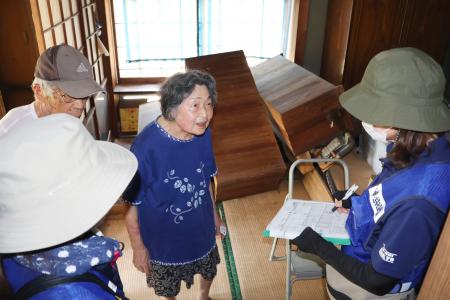 在宅避難する内山幸子さん(中央)に支援ニーズを聞き取る熊本県宇城市の社会福祉協議会の保健師ら=5日、宇城市