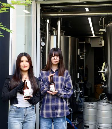 　クラフトビール「酔（よ）いちご」の開発に取り組む大学生。奥は醸造用のタンク＝６月、水戸市