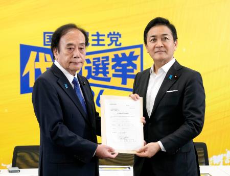 国民民主党の代表選立候補の届け出をする玉木代表。左は上田清司選管委員長＝７日午前、国会