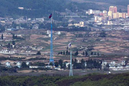 　韓国・坡州から見た北朝鮮との軍事境界線近辺。北側と南側にそれぞれの国旗が掲げられている＝５月（聯合＝共同）