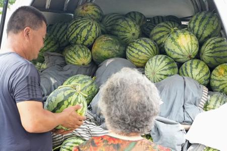 車の荷台に積み上げられ、売られるスイカ＝７月、北京（共同）