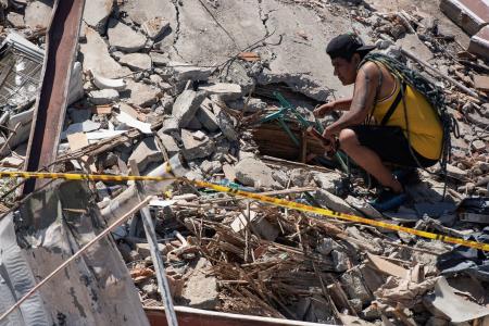 １０日、コロンビア西部カリで、地震で倒壊した建物のがれきをかき分ける男性（ロイター＝共同）