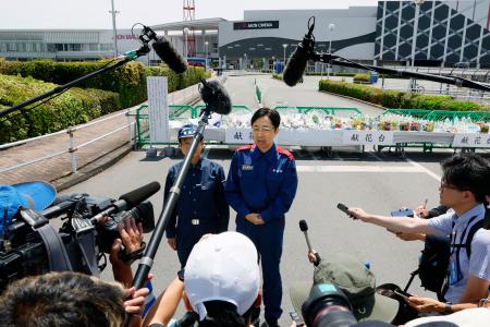 爆発の起きた「イオンモール熊本」で献花を終え、取材に応じる熊本県の木村敬知事（中央右）＝１１日午後、熊本県嘉島町