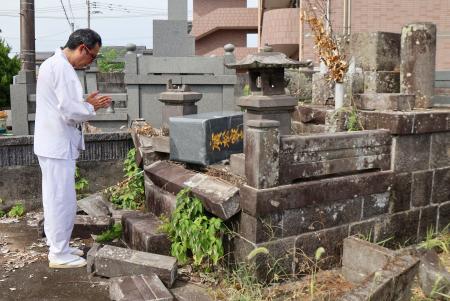 父の墓に手を合わせる廣松克房さん＝１０日、熊本県氷川町