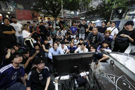 東京・渋谷のハチ公前広場に設置したテレビでブラジル戦を見る人たち＝６月