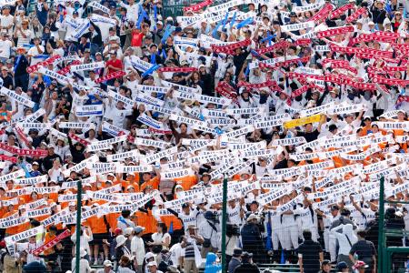 長崎日大に勝利し、タオルを掲げる有明の応援団＝１３日、甲子園球場