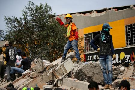 地震で建物が壊れた現場で救助活動をするボランティア＝１２日、コロンビア・ペレイラ（ロイター＝共同）