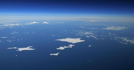 北海道・根室沖から望む北方四島。歯舞群島（中央）、色丹島（右上）、国後島（左奥）が広がり、はるか右奥にはうっすらと択捉島が見える＝２０１９年１月