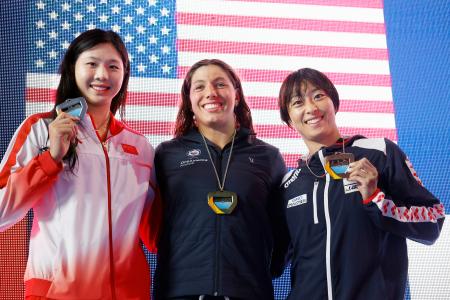 女子100メートル平泳ぎで3位となり、表彰式で笑顔を見せる鈴木聡美(右)=アーバイン(共同)