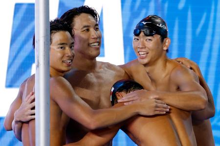 男子400メートルリレーで3位となり抱き合う(左から)村佐達也、松元克央、光永翔音。手前は最終泳者の松本周也=アーバイン(共同)