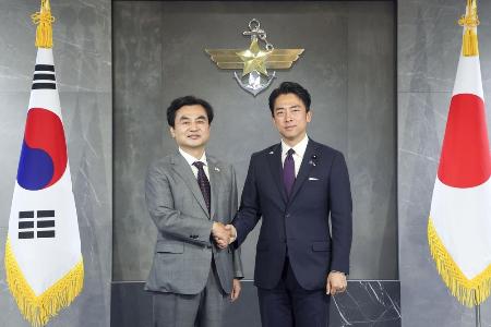6月28日、ソウルの韓国国防省で握手する小泉防衛相(右)と韓国の安圭伯国防相(韓国国防省提供・共同)
