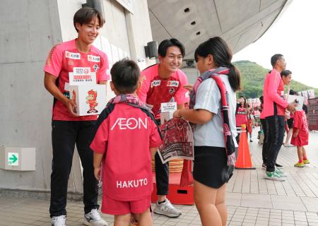 　試合前、寄付を呼びかけるＪ３熊本の選手たち。左端は吉岡＝１５日、熊本市のえがお健康スタジアム