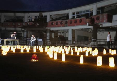 東日本大震災で被災した旧大川小で、犠牲者に思いをはせ明かりがともされた紙灯籠=15日夕、宮城県石巻市