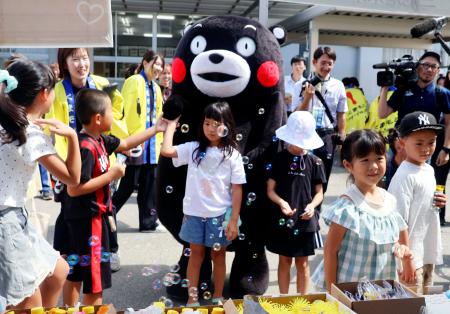 避難所となっている小学校で子供たちと交流する「くまモン」＝１６日午前、熊本県氷川町
