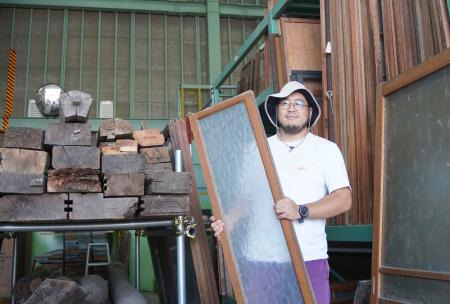 古材の保管展示施設「ビバーク」の運営や企画を担う丸山僚介さん＝７月、神戸市長田区