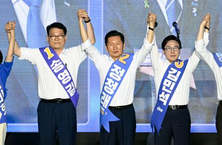韓国与党「共に民主党」の党大会で手を取り合う（右から）金民錫氏、鄭清来氏ら候補者＝１７日、韓国・大田（共同）