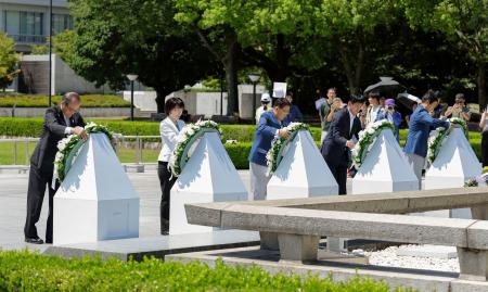 愛知・名古屋アジア大会の聖火リレー採火式で、原爆慰霊碑に献花する広島市の松井一実市長(左端)ら=20日午前、広島市の平和記念公園