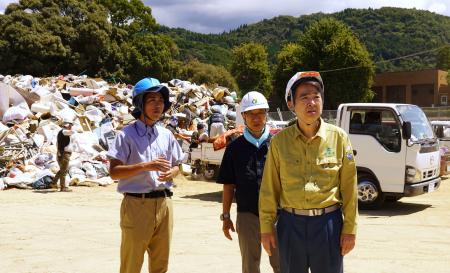 熊本県宇城市の災害ごみ仮置き場を視察する石原環境相（手前）＝２０日午後