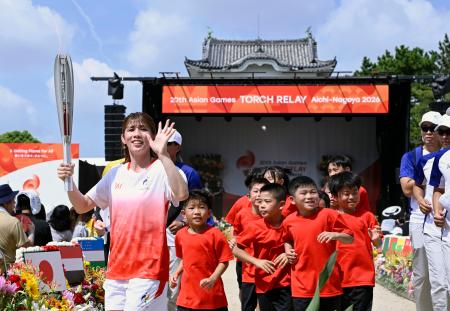 愛知・名古屋アジア大会の聖火リレーがスタートし、名古屋城の広場を走る第１走者の吉田沙保里さん＝２２日午前、名古屋市中区