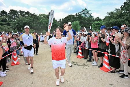 愛知・名古屋アジア大会の聖火リレーで手を振る鍵山優真。奥は名古屋城天守閣＝２２日、名古屋市北区（代表撮影）